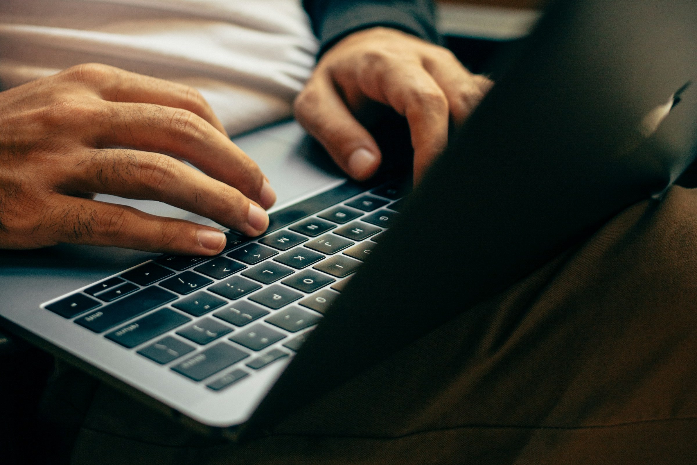 Hände tippen auf der Tastatur eines Notebooks